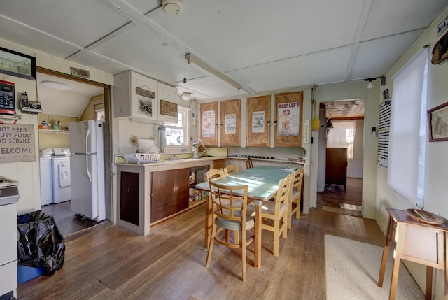 kitchen with washer / clothes dryer, hardwood / wood-style floors, and white refrigerator