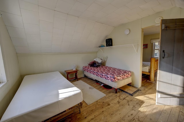 bedroom with light hardwood / wood-style flooring and lofted ceiling