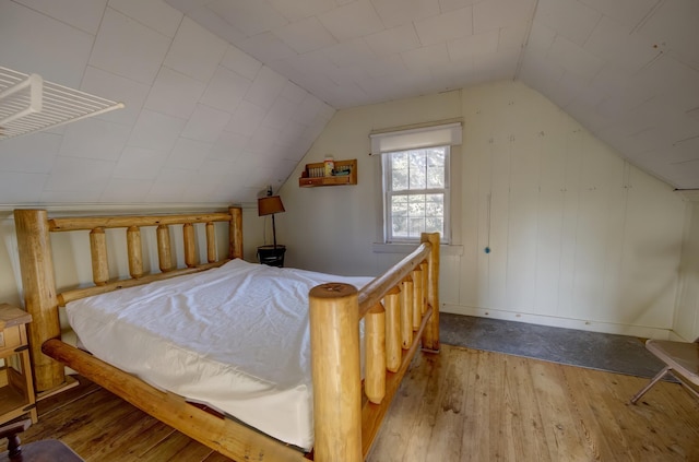 bedroom with wood-type flooring and lofted ceiling