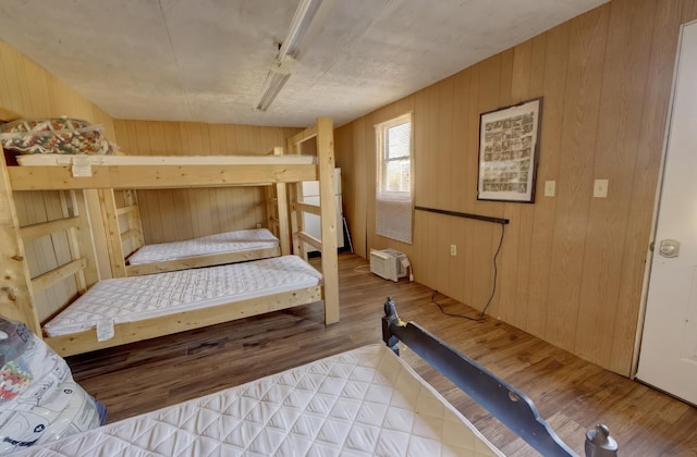 bedroom featuring wooden walls and light hardwood / wood-style flooring