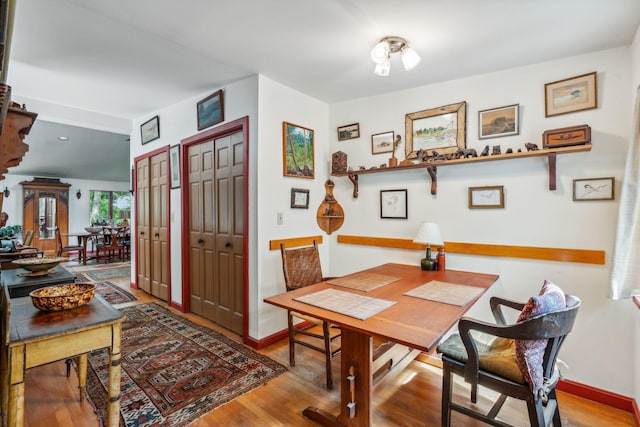 dining space with baseboards and wood finished floors