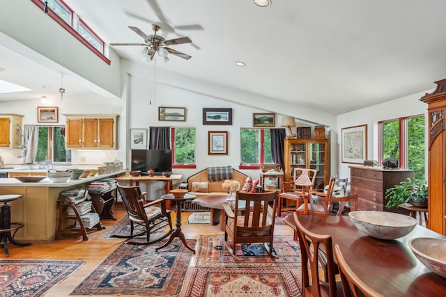 living room featuring light wood finished floors, a ceiling fan, lofted ceiling, and recessed lighting