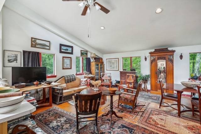 living room with a wealth of natural light, a ceiling fan, light wood-style floors, and lofted ceiling
