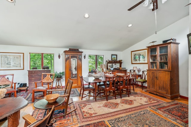 dining room featuring wood finished floors, ceiling fan, lofted ceiling, and a wealth of natural light