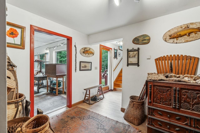 sitting room featuring wood finished floors, baseboards, and stairs