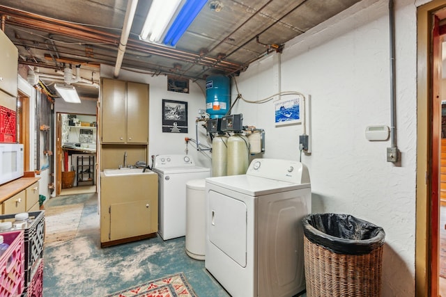 washroom featuring independent washer and dryer, laundry area, and a sink