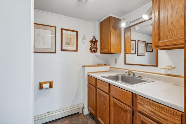 kitchen featuring a sink, light countertops, a baseboard radiator, crown molding, and brown cabinets
