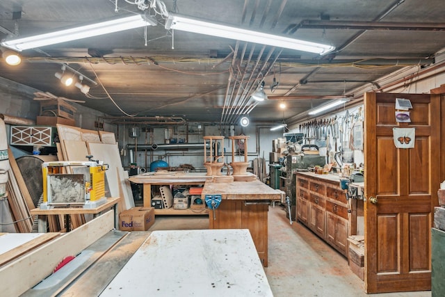 miscellaneous room with a workshop area and unfinished concrete floors