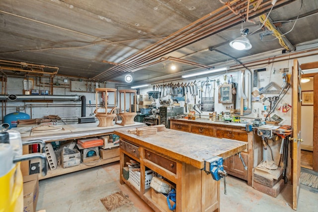 miscellaneous room featuring a workshop area and unfinished concrete floors