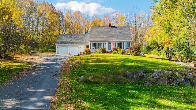 cape cod-style house featuring a garage and a front lawn