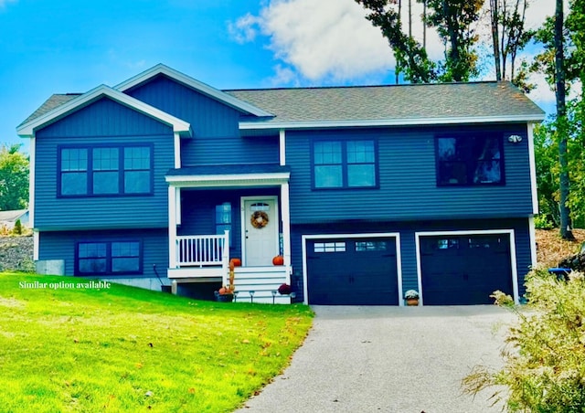 raised ranch featuring a front lawn, a garage, and covered porch