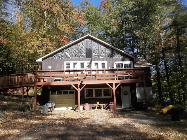 rear view of house featuring a garage and a deck