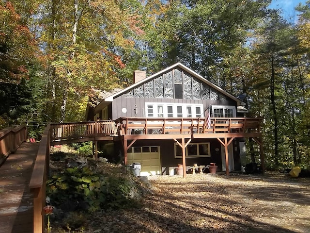 back of house with a wooden deck and a garage