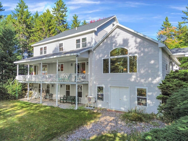 rear view of property featuring a yard and a patio area