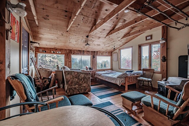 bedroom featuring vaulted ceiling with beams, multiple windows, hardwood / wood-style floors, and wood ceiling