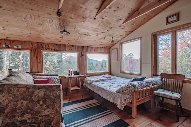 bedroom with wood walls, vaulted ceiling, wooden ceiling, and light hardwood / wood-style flooring