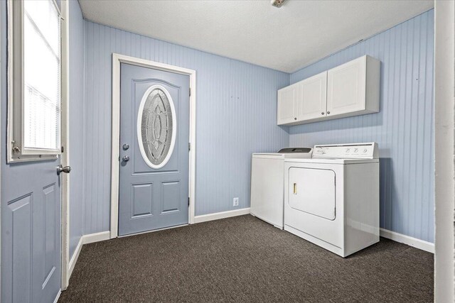 laundry room with dark carpet, independent washer and dryer, a textured ceiling, and cabinets