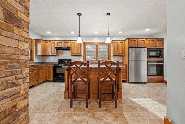 kitchen with tasteful backsplash, a breakfast bar area, black appliances, decorative light fixtures, and a center island