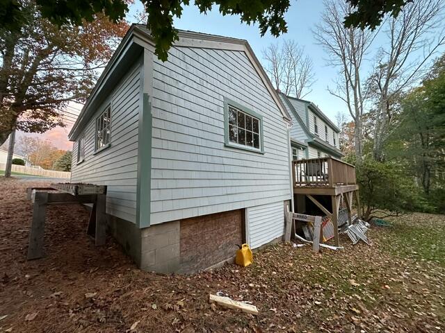 property exterior at dusk featuring a deck