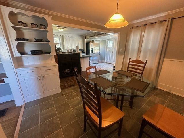 tiled dining space featuring ornamental molding