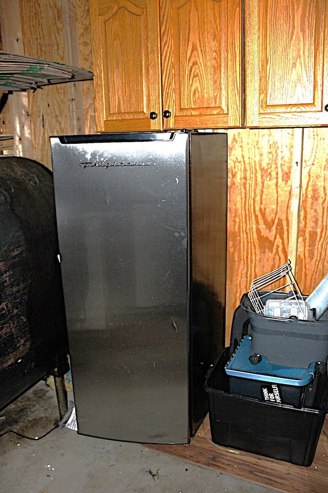 room details with freestanding refrigerator and brown cabinetry