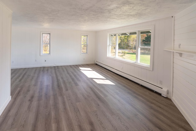 954 Mason Bay Rd, Jonesport, ME 04649 - spare room with a baseboard heating unit, wood finished floors, a textured ceiling, and wood walls