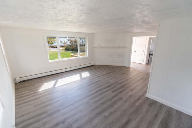 954 Mason Bay Rd, Jonesport, ME 04649 - unfurnished room featuring baseboard heating, wood finished floors, and a textured ceiling