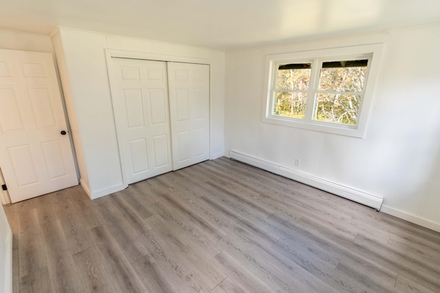 954 Mason Bay Rd, Jonesport, ME 04649 - unfurnished bedroom featuring a baseboard heating unit, wood finished floors, and a closet