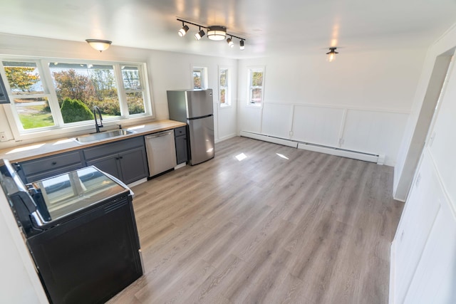 954 Mason Bay Rd, Jonesport, ME 04649 - kitchen featuring appliances with stainless steel finishes, a baseboard radiator, light wood-style floors, wainscoting, and gray cabinets