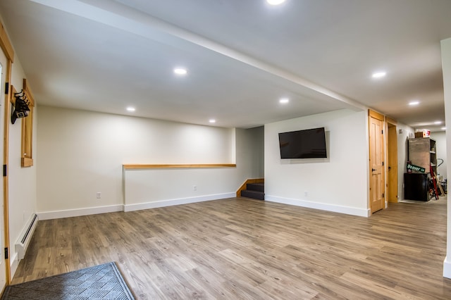 unfurnished living room with baseboard heating and light hardwood / wood-style flooring