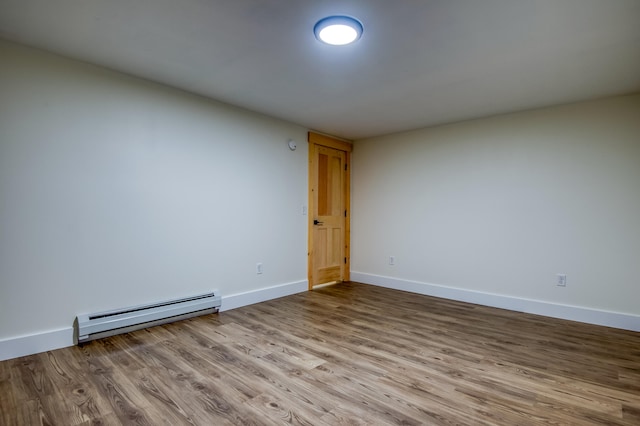 unfurnished room featuring light hardwood / wood-style flooring and a baseboard heating unit