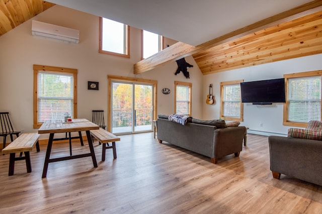 living room with a wall mounted air conditioner, light hardwood / wood-style floors, baseboard heating, and a wealth of natural light