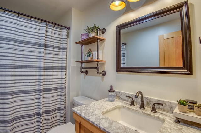 bathroom featuring vanity, toilet, and walk in shower