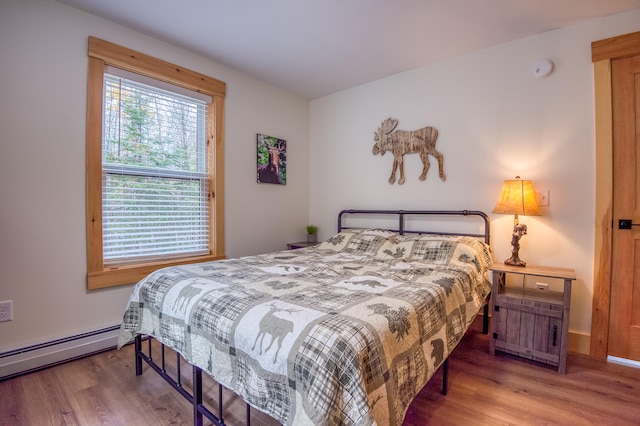 bedroom with baseboard heating and hardwood / wood-style flooring