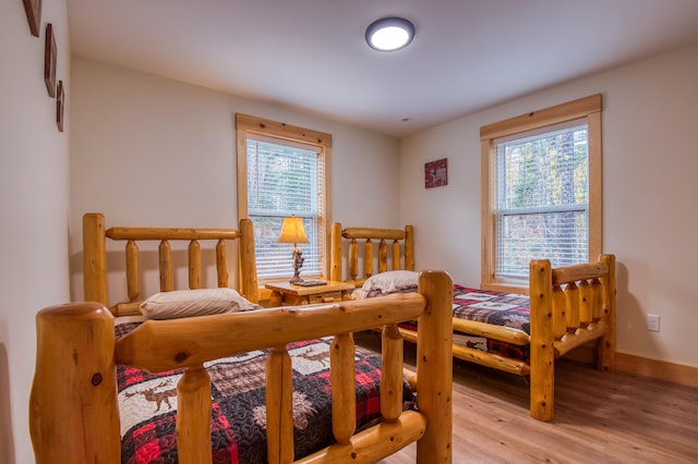 bedroom with light hardwood / wood-style floors and multiple windows