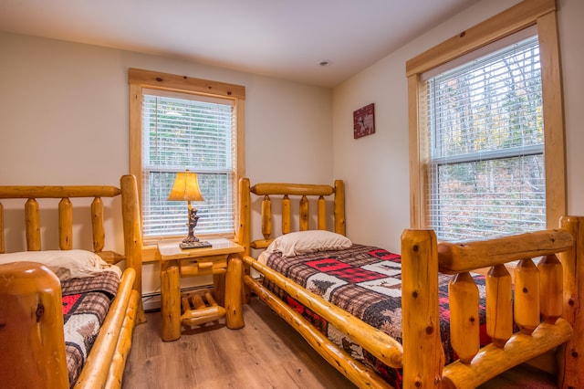 bedroom featuring wood-type flooring and baseboard heating