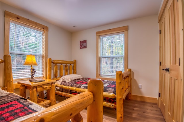 bedroom with multiple windows and light hardwood / wood-style flooring