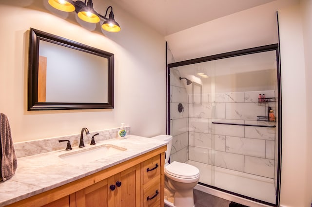 bathroom with vanity, toilet, and a shower with door