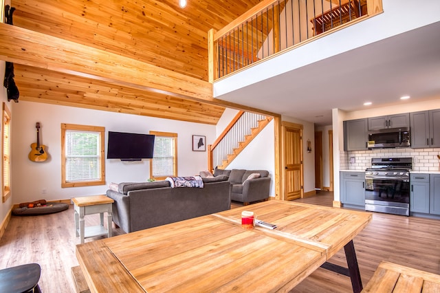 dining room with wooden ceiling, high vaulted ceiling, and light hardwood / wood-style floors