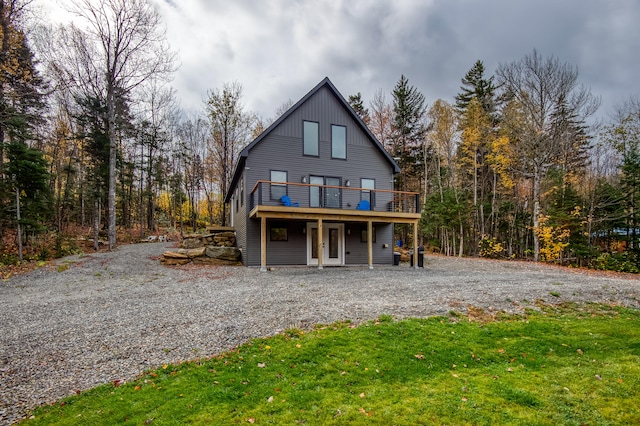 back of property featuring a lawn and a wooden deck