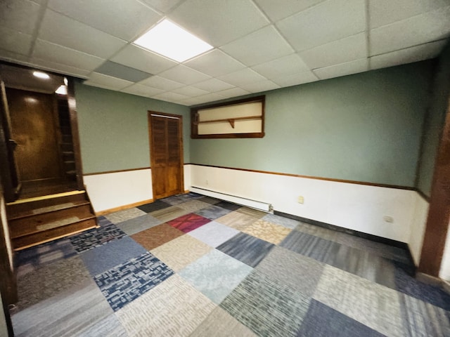 376 Fort Fairfield Rd, Caribou, ME 04736 - finished basement featuring a baseboard radiator, stairs, and a paneled ceiling