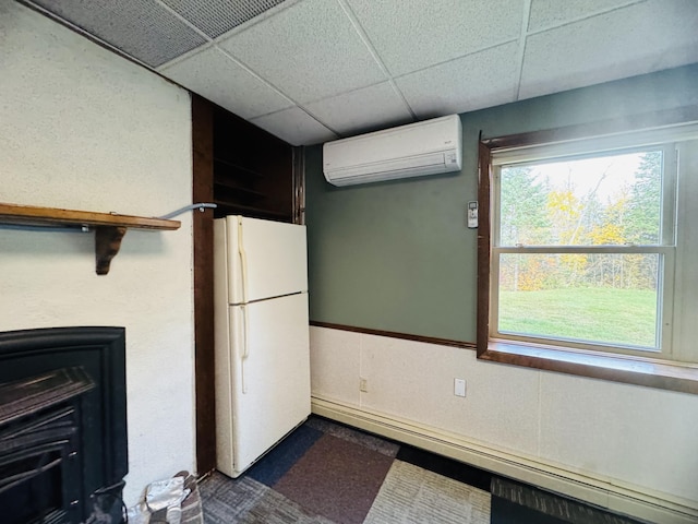 376 Fort Fairfield Rd, Caribou, ME 04736 - kitchen featuring freestanding refrigerator, a wall mounted AC, a baseboard heating unit, and a paneled ceiling
