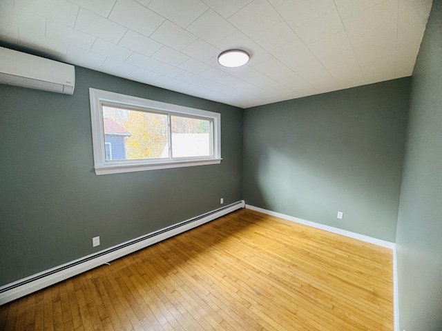 376 Fort Fairfield Rd, Caribou, ME 04736 - unfurnished room featuring baseboard heating, a wall unit AC, and hardwood / wood-style flooring