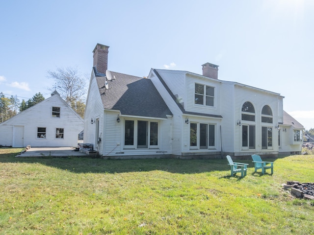 back of house featuring a lawn and a patio