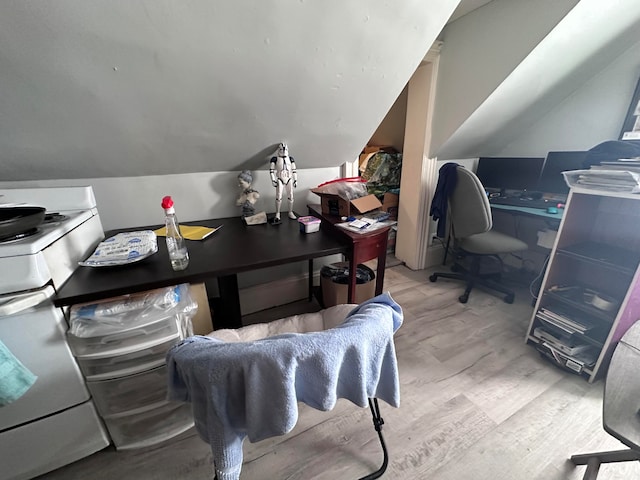 home office with vaulted ceiling and light hardwood / wood-style floors