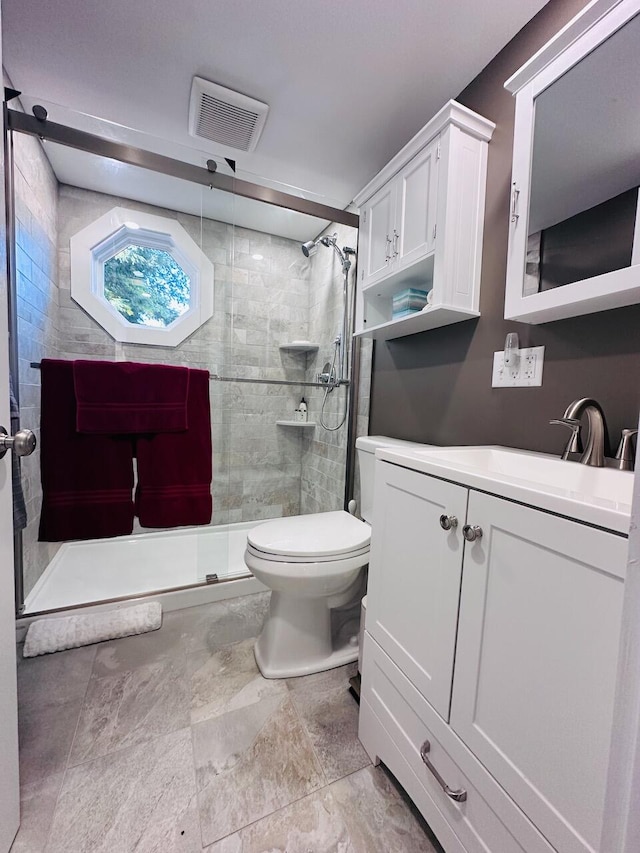 bathroom featuring visible vents, toilet, a shower stall, and vanity