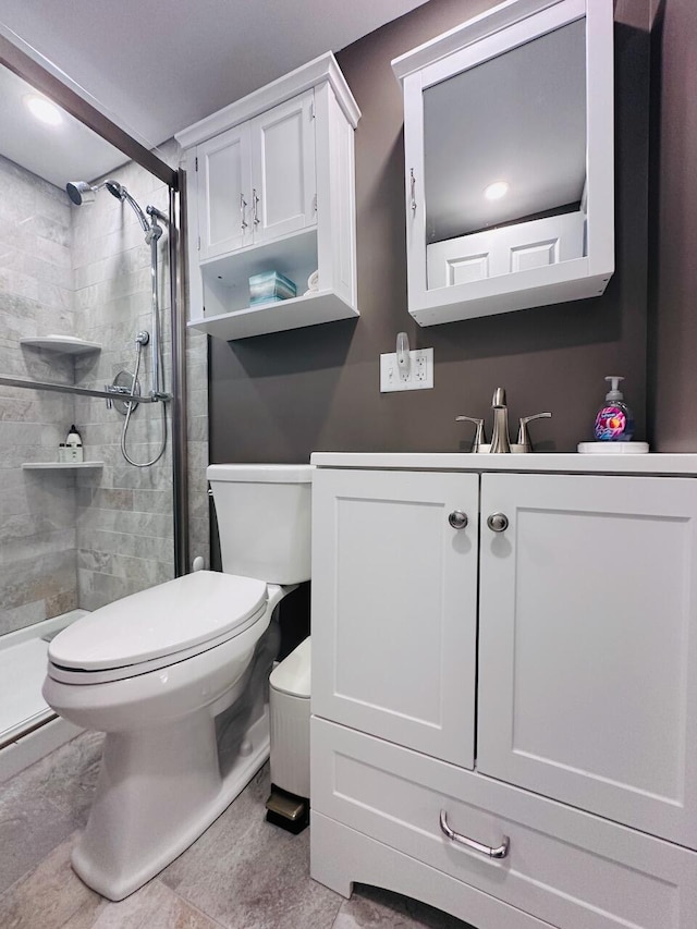 full bathroom with vanity, a shower stall, and toilet