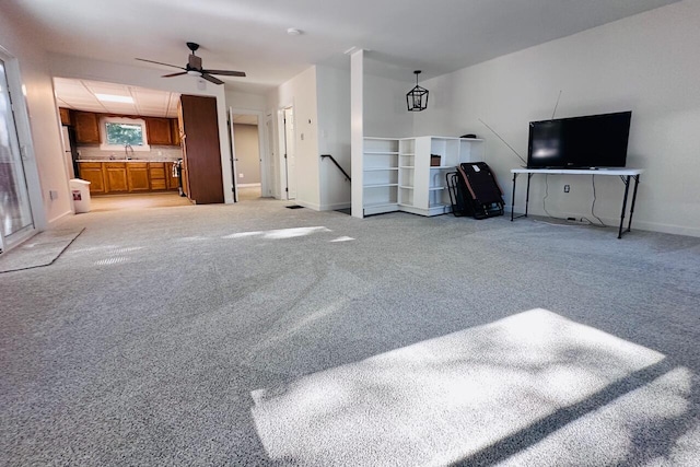 living room with light carpet, ceiling fan, and baseboards