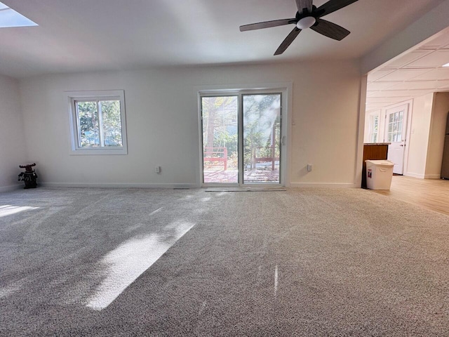 empty room with light carpet, ceiling fan, and baseboards