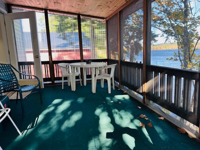 sunroom / solarium featuring wooden ceiling and a water view